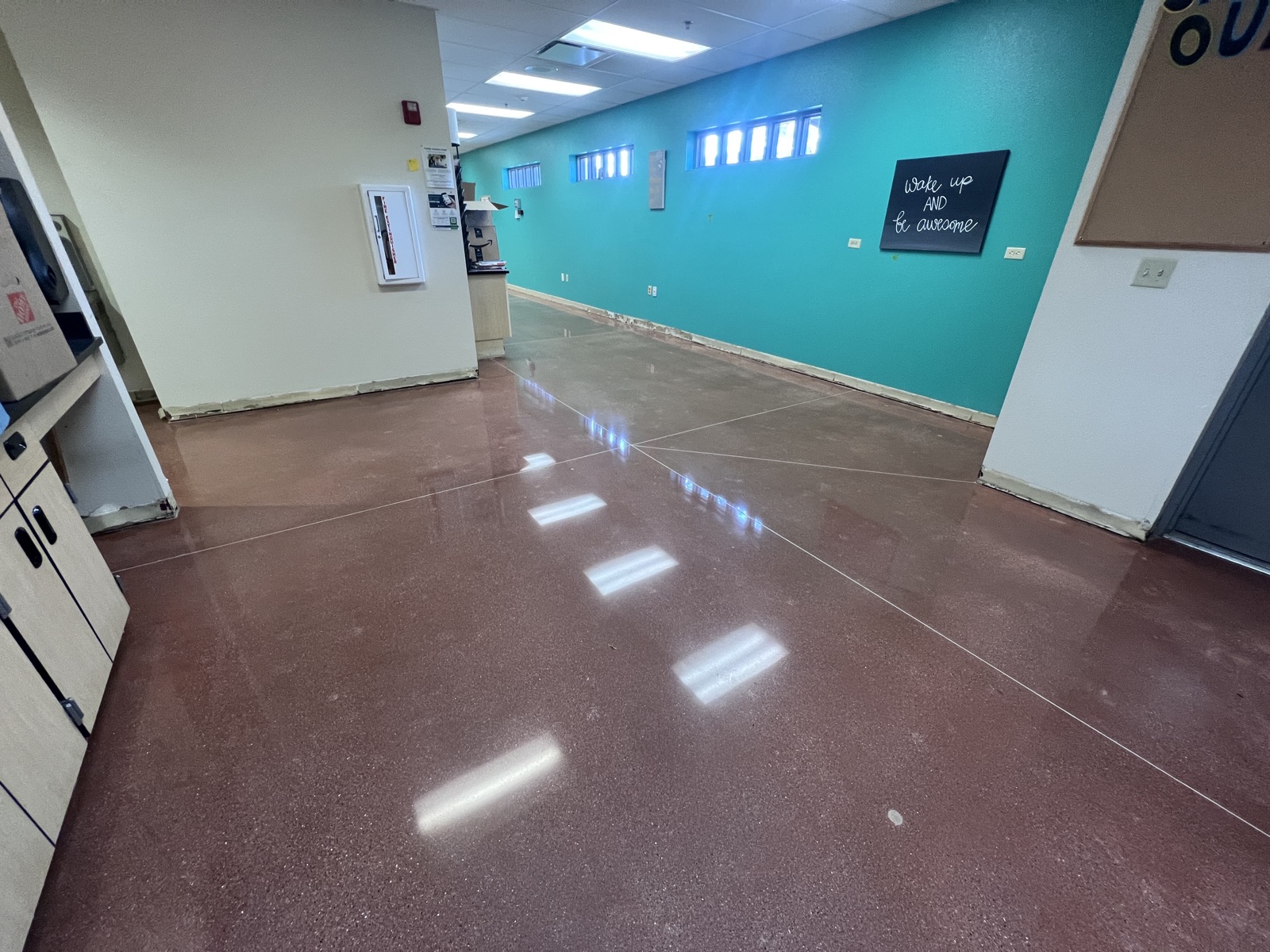 Tinted polished concrete floor in an early-childhood facility with a teal accent wall