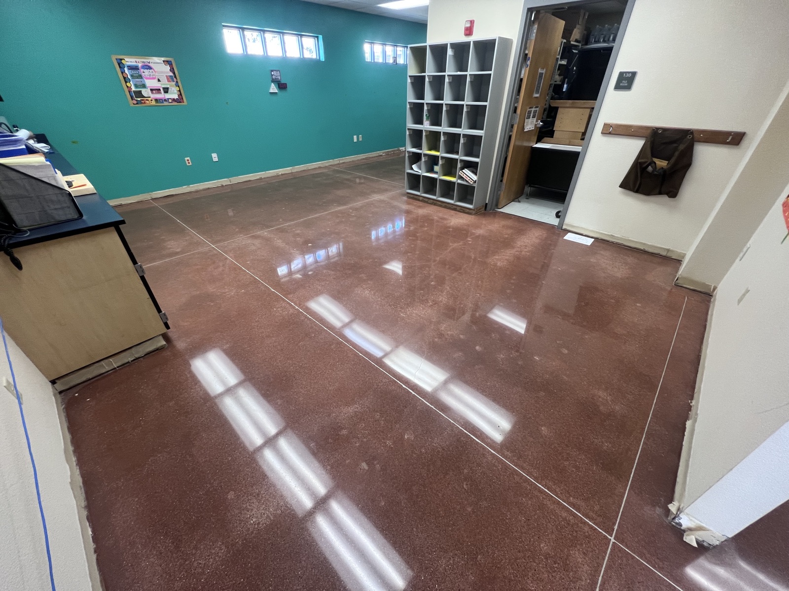 Decorative resinous flake floor in a commercial office with teal accent wall